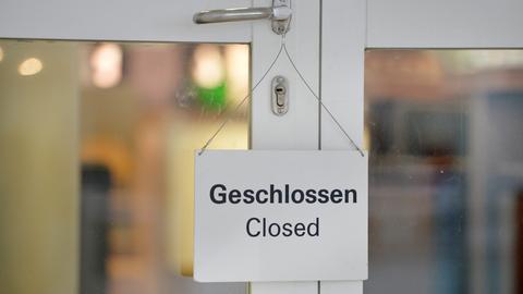 An einer Tür hängt ein Schild "Geschlossen"