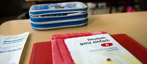 Schulbücher liegen auf einem Pult.