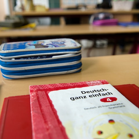Schulbücher liegen auf einem Pult.