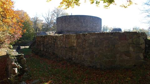 Die Überreste einer Steinmauer und eines Burgturms