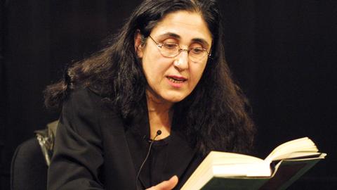 Portrait von Sevgi Özdamar während sie aus einem Buch liest.