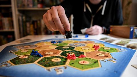 Spieler spielen das Spiel "Siedler von Catan".