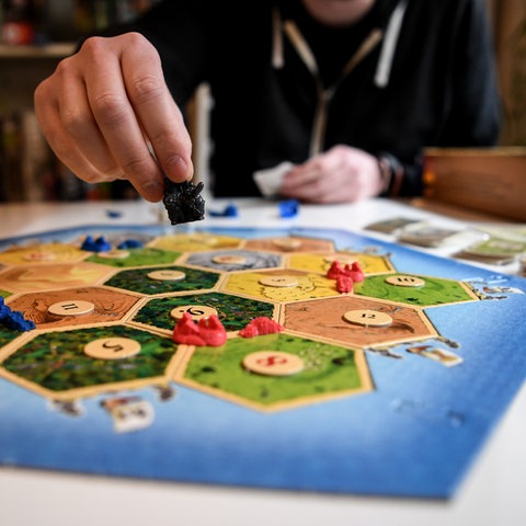 Spieler spielen das Spiel "Siedler von Catan".