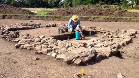 Archäologe arbeitet an steinernem Fundament