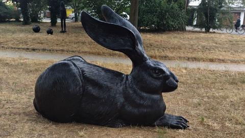 Skulptur eines schwarzen Hasen im Park