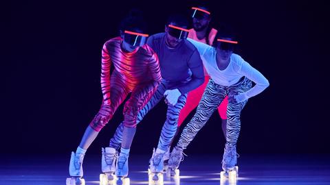 Vier Tänzer auf Rollerskates mit Zebra Catsuits und spaceigen Sonnenbrillen
