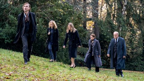 Murot und seine Assistentin Magda laufen mit der Familie Muthesius eine Wiese entlang.
