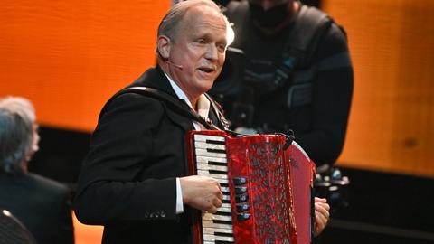 Ulrich Tukur spielt Akkordeon.