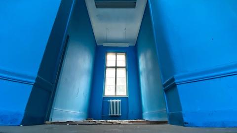Foto eines blauen Treppenabsatzes aus der Ameisenperspektive im Alten Polizeipräsdium in Frankfurt