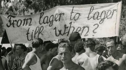 Junge Männer halten ein Transparent "From lager to lager till when?""