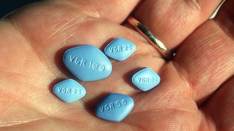 Fünf Viagra-Pillen liegen auf der Handfläche eines Mannes