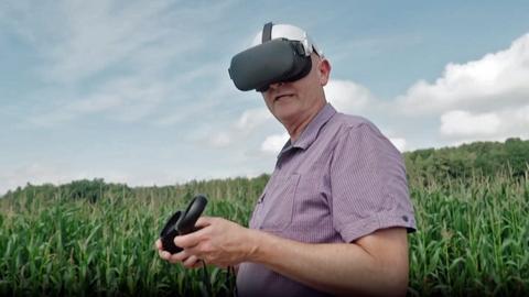 Mann mit VR-Brille auf einem Acker