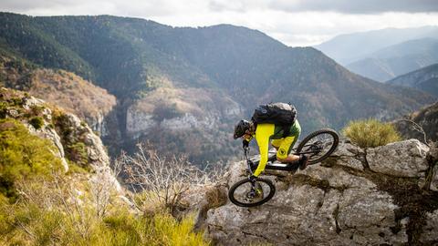 Mountainbiker in gelben Trikot im Gebirge