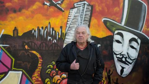 Willy Praml vor einem Graffito