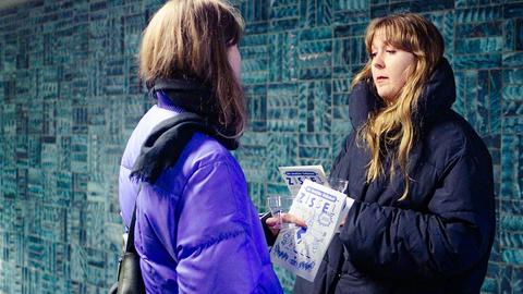 Zwei junge Frauen halten ein Flugblatt in der Hand