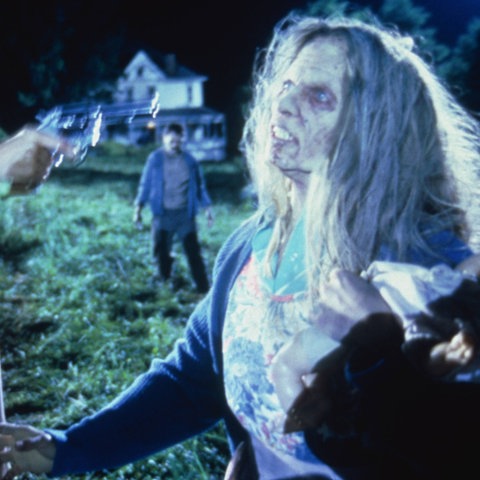 Eine Frau zielt mit einer Pistole auf eine weibliche Zombie-Figur.
