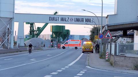 EIn Blick in die Straße und das Werk in den Morgenstunden. Auf einer Brücke steht "Durst Malz-Union Malz".