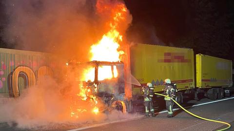 Feuerwehrleute löschen einen brennenden Lastwagen auf der A3 bei Niedernhausen.