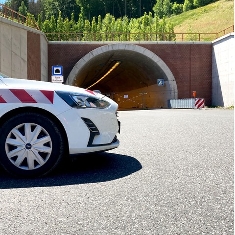 Bildkombination: links Ein Einsatzwagen der Autobahn GmbH parkt vor dem Eingang des Tunnels Hirschhagen auf der Autobahn A44. Rechts daneben eine Karte, auf welcher der Tunnel lokalisiert ist.