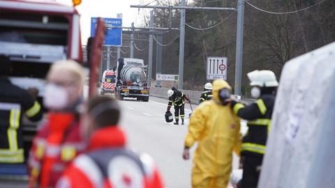 Ein Lkw steht auf dem rechten Standstreifen einer Autobahn. Drumherum Einsatzkräfte von Feuerwehr und Notfallrettung.
