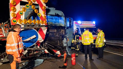 Unfall-Lkw in demolierter Baustelle auf der Autobahn 60, Einsatzkräfte stehen daneben, es ist Nacht