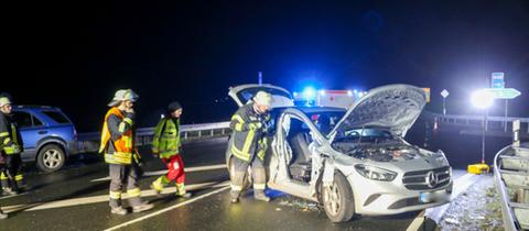 Beschädigter Mercedes nach einem Unfall nahe der A66-Anschlussstelle Neuhof, daneben Rettungskräfte