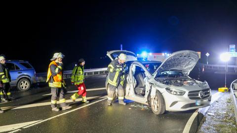 Beschädigter Mercedes nach einem Unfall nahe der A66-Anschlussstelle Neuhof, daneben Rettungskräfte