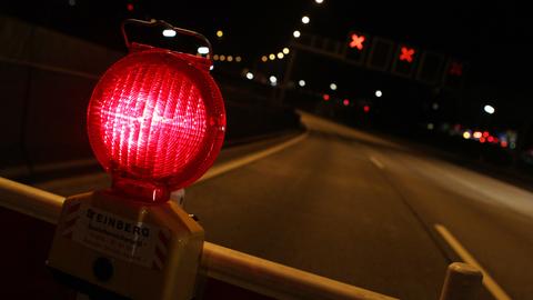 Symbolbild: Eine rote Warnlampe steht auf einer gesperrten Autobahn. 