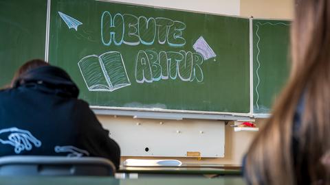 "Heute Abitur" steht auf einer Tafel im Klassenzimmer eines Gymnasiums. 