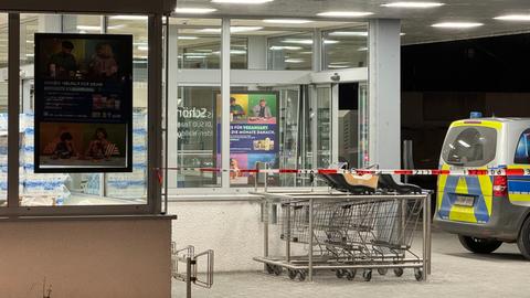 Im Dunkeln beleuchteter Supermarkt mit Polizeiauto