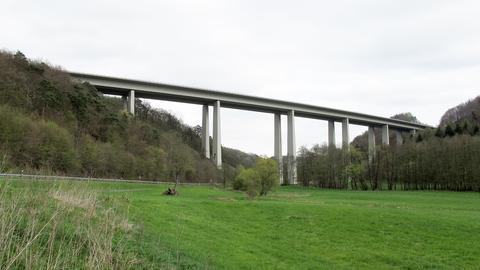 Eine Autobahnbrücke, die auf hohen Stelen stehend, ein Tal überspannt.