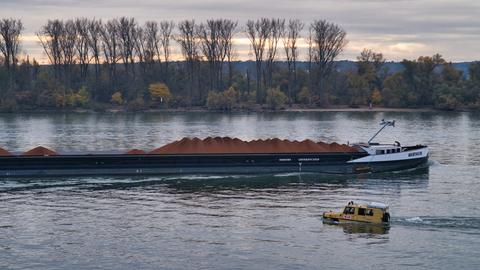 Ein Amphibienfahrzeug schwimmt und fährt im Rhein. 