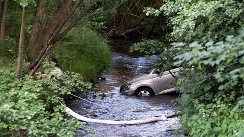 Ein Auto steht schräg in einem Fluss