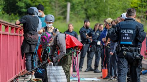 Autobahngegner und Polizisten stehen auf einer Brücke über der A4.