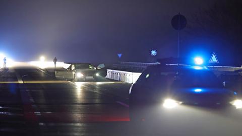 Schwarzes Auto mit offenen Türen im Dunkeln auf Brücke