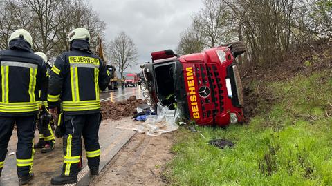 Ein roter Laster liegt seitlich umgekippt auf der B27.