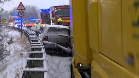 Autounfall auf der B454 bei Stadtallendorf, Auto eingeklemmt zwischen Lastwagen und Leitplanke auf schneeglatter Fahrbahn