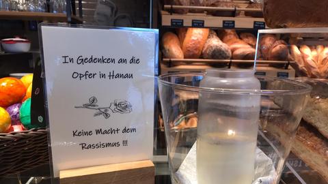 Eine Hanauer Bäckerei hat eine Gedenktafel und eine Kerze für die Opfer aufgestellt.