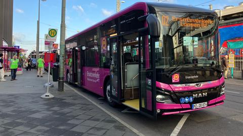 Ein Bus steht am Frankfurter Hauptbahnhof. Menschen in gelben Warnwesten stehen für Auskünfte bereit.