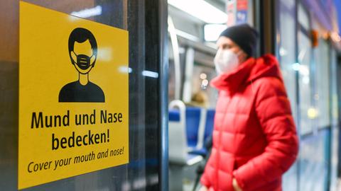 Ein Mann mit Maske steigt in einen Zug.
