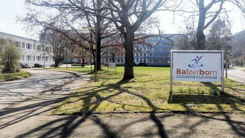 Rehaklinik Bad Sooden-Allendorf von außen. Im Vordergrund ein Schild auf dem "Balzerborn Gesundheitszentrum" steht. 