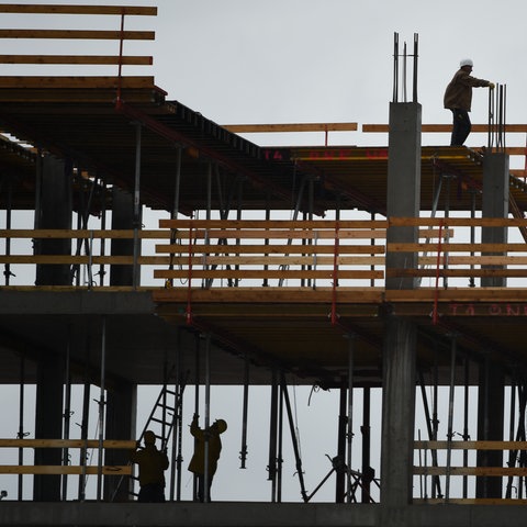 Bauarbeiter auf einer Baustelle im Gegenlicht