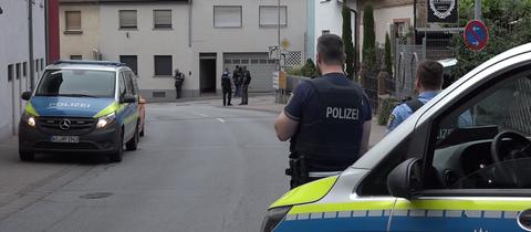 Polizei und SEK versammelt auf der Straße vor Haus, in dem Einsatz läuft