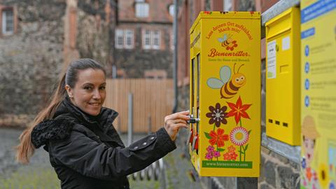 Frau an einem Bienenfutter-Automaten in Hanau