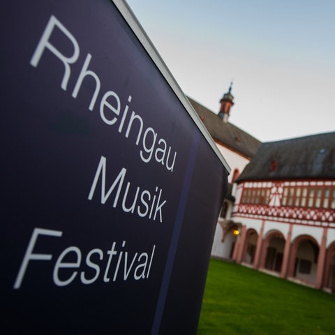 Das Plakat "Rheingau Musik Festival" steht im historischen Innenhof des Klosters. 