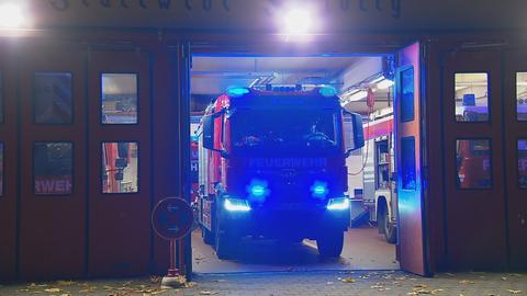 Ein Feuerwehrauto fährt aus einer Garage heraus. 