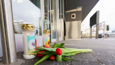 Kerzen und Blumen vor dem Eingangsbereich des Supermarkts, in dem eine Kassiererin von ihrem Ex-Partner getötet wurde