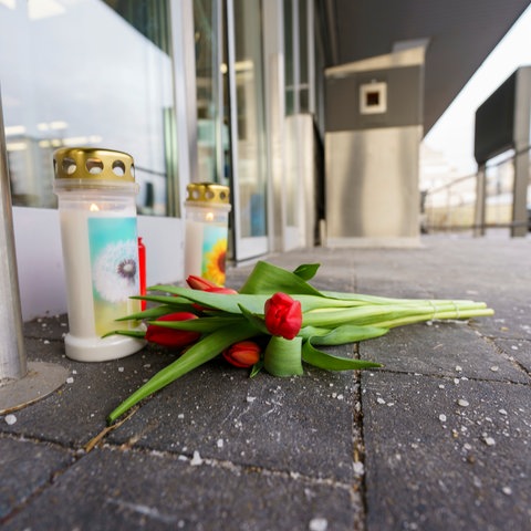 Kerzen und Blumen vor dem Eingangsbereich des Supermarkts, in dem eine Kassiererin von ihrem Ex-Partner getötet wurde