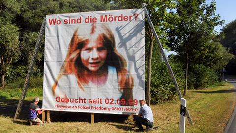 2009: Polizeibeamte bauen ein Plakat auf, mit dem zu Hinweisen im Mordfall der kleinen Johanna Bohnacker aufgerufen wird.