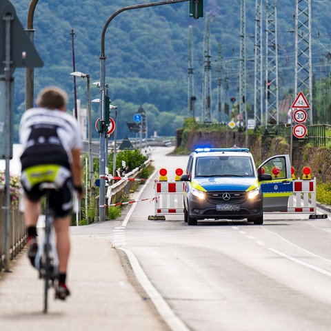 Polizeiwagen an Straßensperrung neben dem Rhein